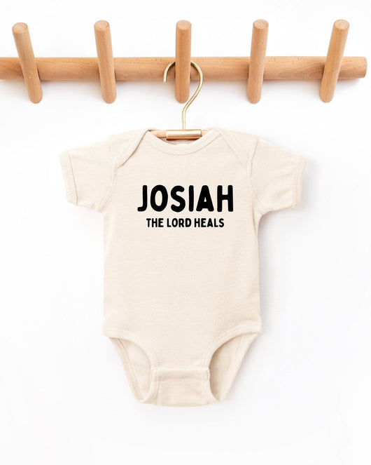 Beige baby onesie with 'Josiah The Lord Heals' text on a white background